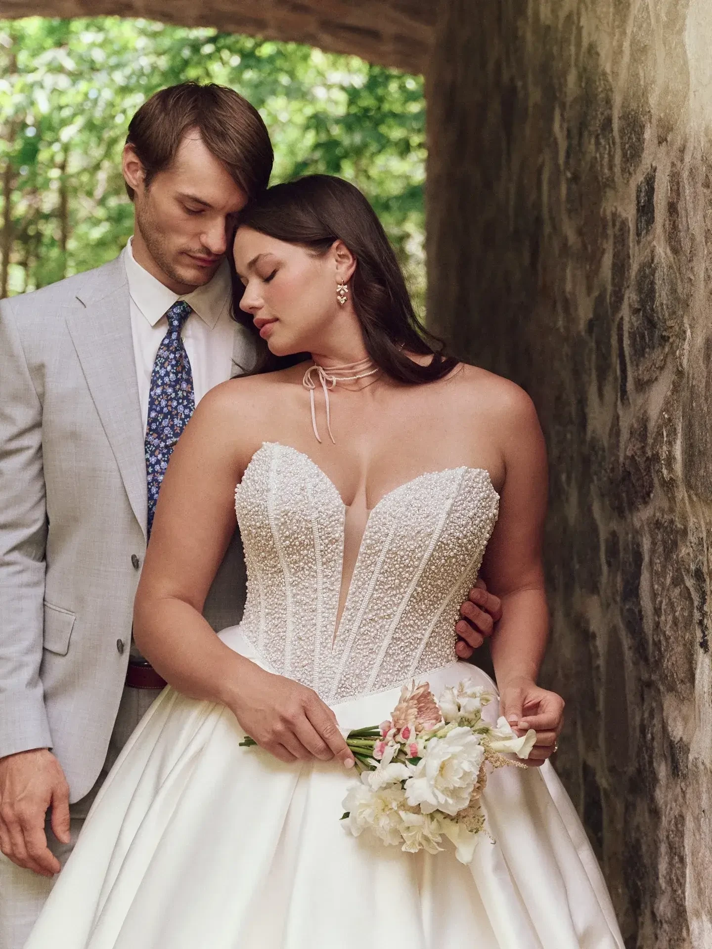 model is wearing a plus size strapless ball gown wedding dress