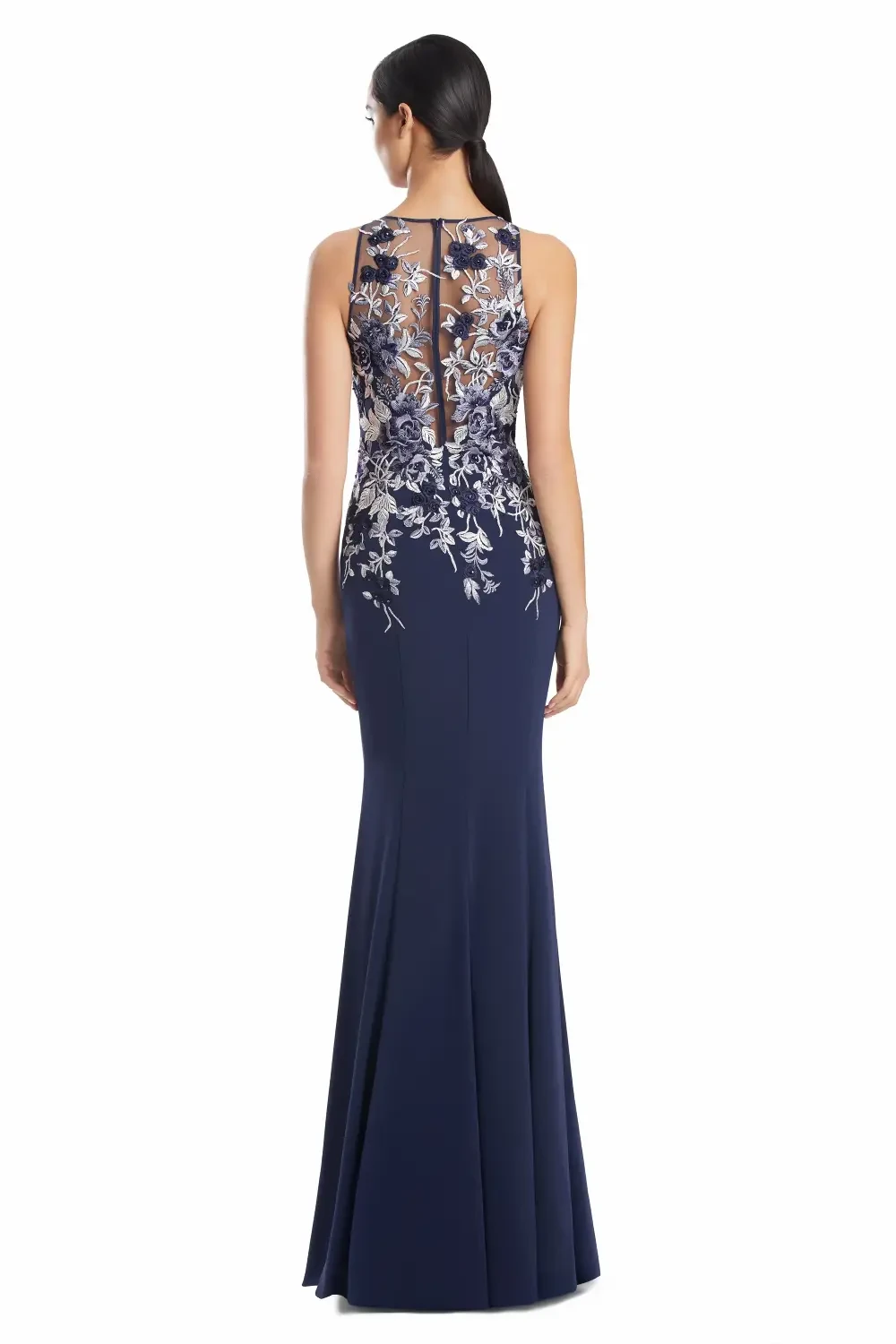 Woman wearing a fitted navy blue evening gown with floral embroidery.
