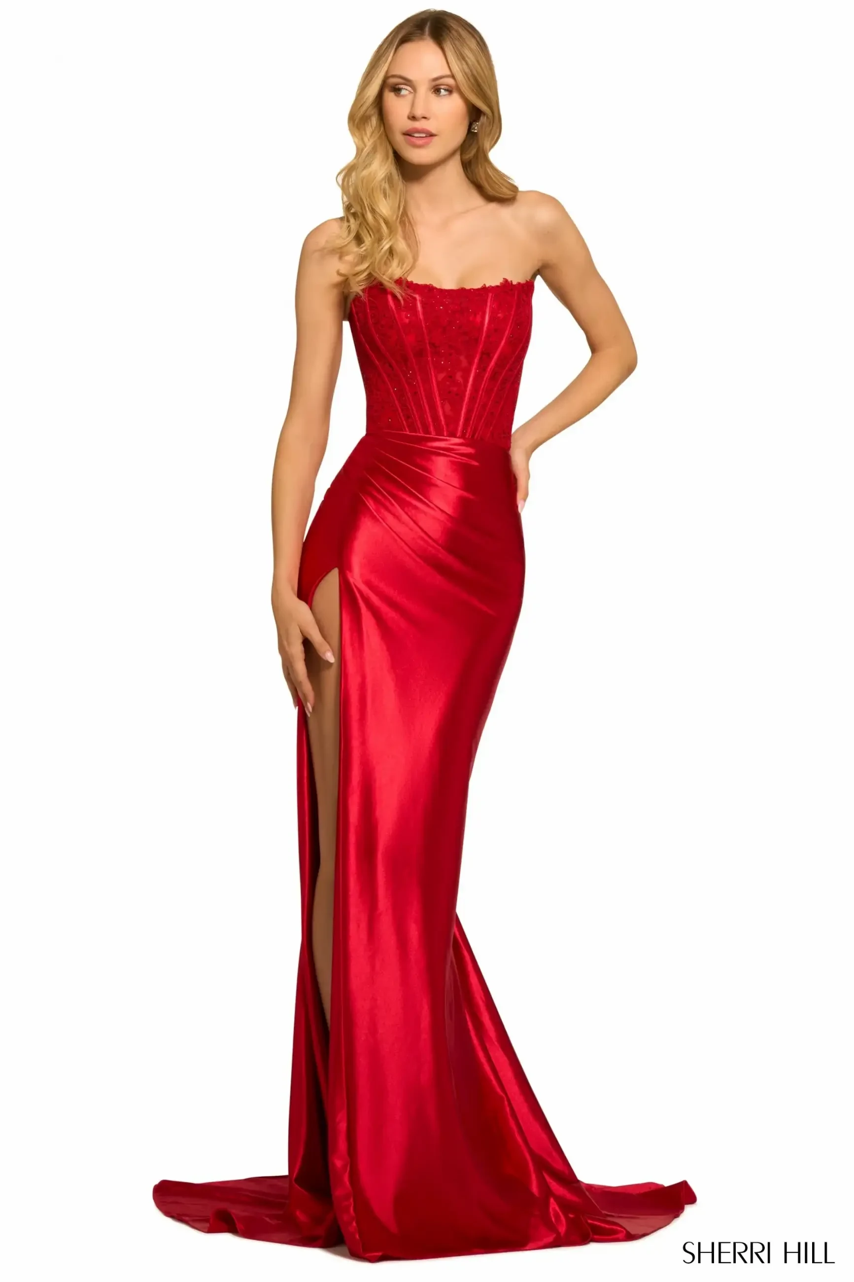 A woman in a strapless red gown with a fitted bodice and a high slit.