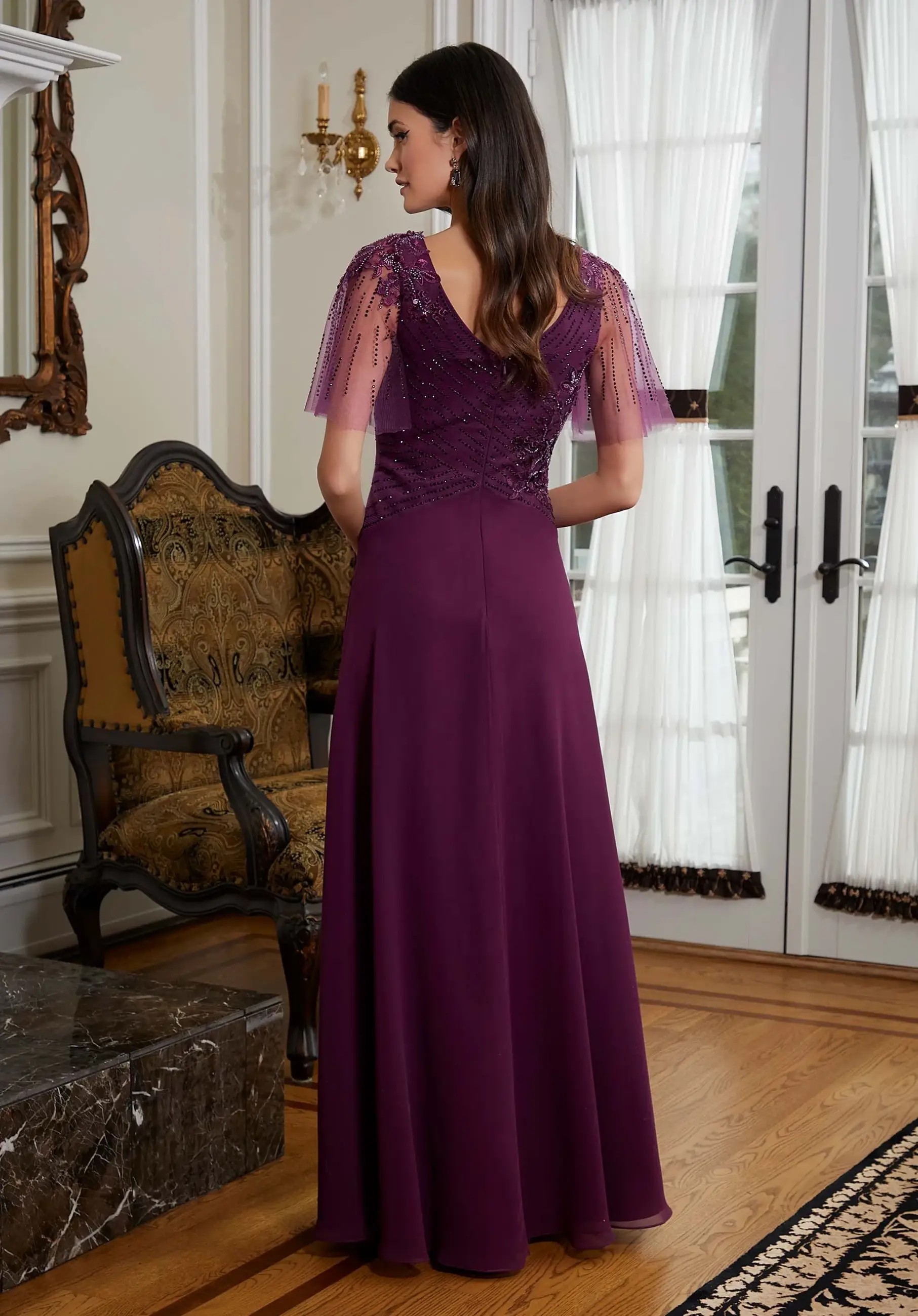 Model is wearing a chiffon A-line mothers dress by morilee