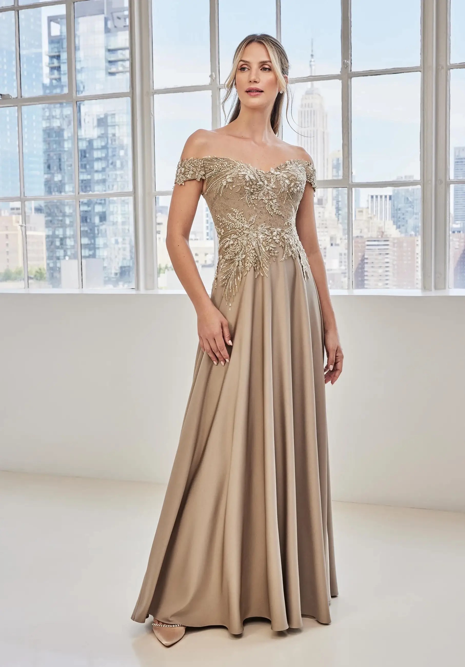 Model is wearing an A-line off the shoulder evening gown from morilee