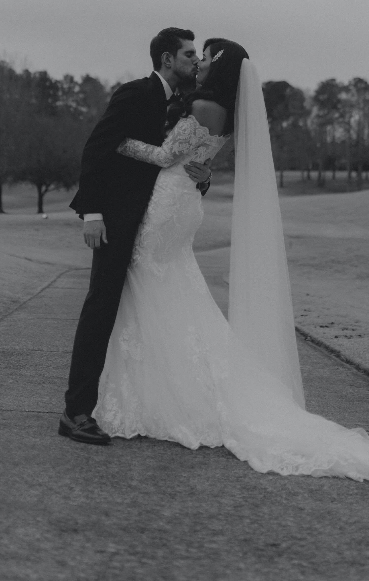 Сouple wearing a white gown and a black suit. Mobile image