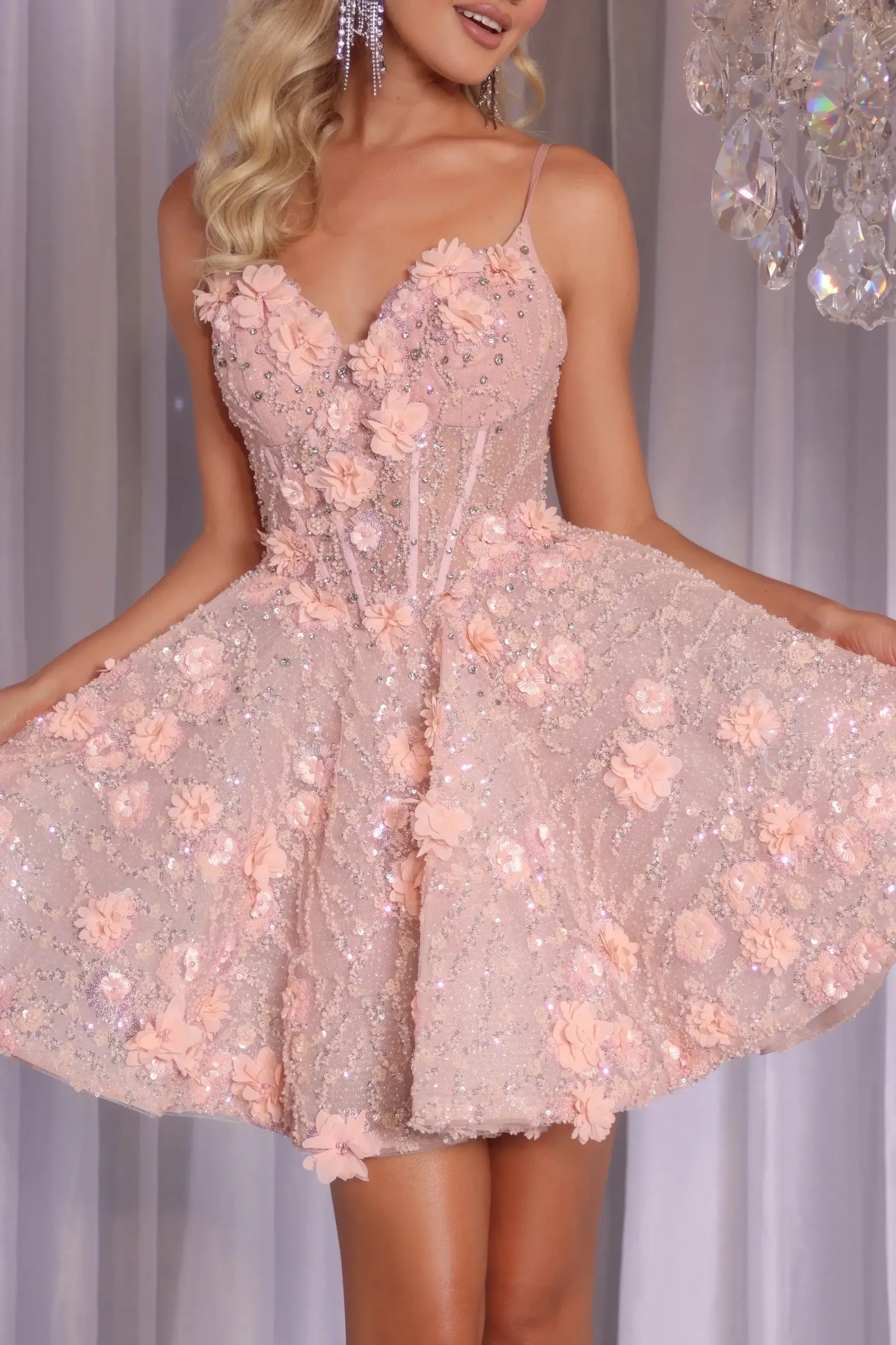 Model is wearing a strapless A-line mini dress with a V-neckline, beaded applique details, and a flared skirt.